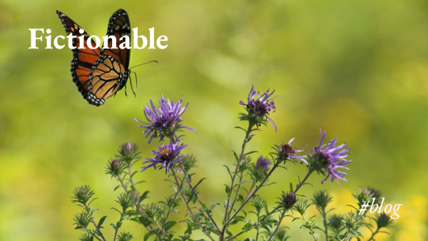 A monarch butterfly coming in to land on a flower, with the words 'Fictionable #blog'