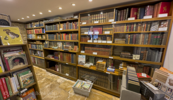 Bookshop interior, dark shelves floor to ceiling with antiquarian books