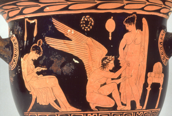 Red-figure vase painting of a crouching winged Eros holding a burning oil lamp, the other hand touching the vulva of a naked woman who is standing in front of him. A mirror on the wall suggests a private chamber. Behind Eros, a seated woman is holding a burning oil lamp as well, looking at her lap.