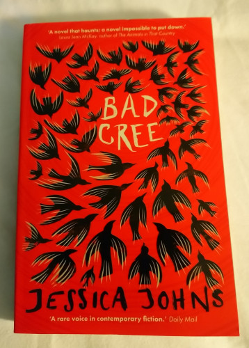 Cover of the book Bad Cree by Jessica Johns: bright red background with numerous black crows circling the title printed in white.
Text at the top: 'A novel that haunts; a novel impossible to put down', Laura Jean McKay, author of The Animals in That Country
Text at the bottom: 'A rare voice in contemporary fiction', Daily Mail 