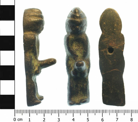 Description from the West Yorkshire Archaeology Advisory Service: “A cast copper alloy anthropomorphic male figurine with an exaggerated phallus possibly dating from the Roman period. It is 66.26mm long, 18.1mm wide and 20.6mm thick. It weighs 60.04gm.The man wears an unusual hat of two, possibly three tiers, pointed at the front. This may be a depiction of a Phrygian cap with its point folded down and forwards. The small and worn face appears to be frowning. Only the nose and hollows for eyes are visible.”