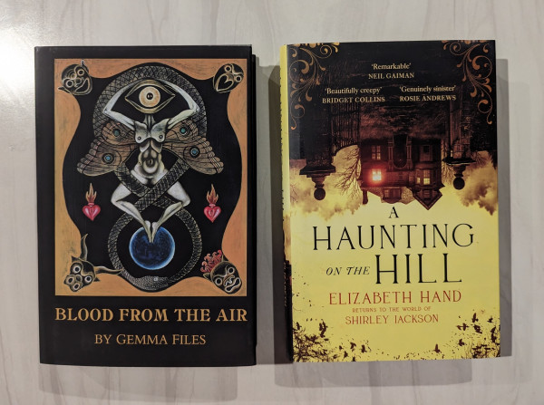 Deluxe hardcover of BLOOD FROM THE AIR by Gemma Files with a surreal collage of a woman's headless body with butterfly/moth wings and her hands raised up to cradle a large eye where her head would be
Hardcover of A HAUNTING ON THE HILL by Elizabeth Hand with an upside down house/mansion enclosed by a gate