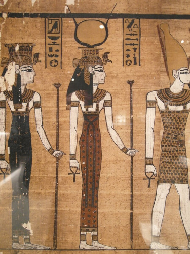 Detail of Hathor in an illustration from the Harris papyrus. She holds a sceptre and an ankh symbol. On her head we see an uraeus crown with a rearing cobra and a sun disk between her bovine horns.