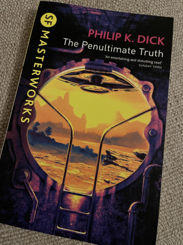Front cover of The Penultimate Truth by Philip K Dick part of the SF Masterworks Collection. The cover shows an open porthole with ladder and through it a rocky landscape with an orange and yellow hue, but with elements of green and trees.