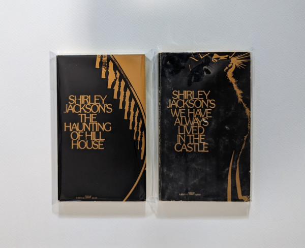 Vintage gold embossed paperbacks of Shirley Jackson's THE HAUNTING OF HILL HOUSE and WE HAVE ALWAYS LIVED IN THE CASTLE