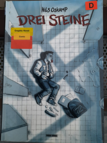 Cover von Drei Steine von Nils Oskamp, mit Bücherei Klebern, zeigt einen Jungen am Boden einer Schultoilette der sich den Bauch hält. Auf ihn fällt der Fensterschatten eines Hakenkreuzes