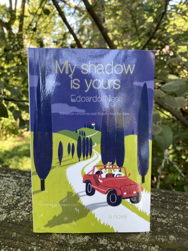 The book cover shows an almost cartoon drawing of a red roofless jeep with two light-skinned men in the front seat holding wineglasses. The shadow of the car looks like a wolf